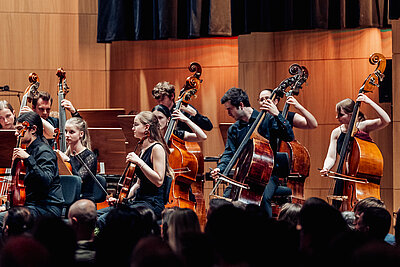 ein Teil des Orchesters spielt auf ihren Streichinstrumenten live auf einer Konzertbühne