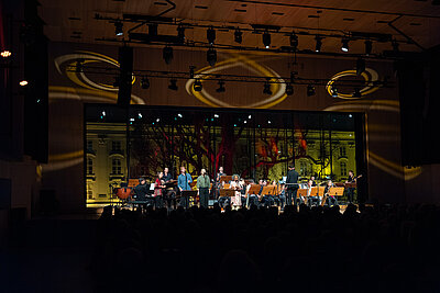Jazzorchester spielt live auf einer beleuchteten Konzertbühne