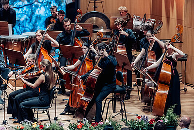ein Teil des Orchesters spielt auf ihren Instrumenten live auf einer Konzertbühne