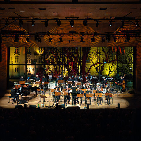 Jazzorchester spielt live auf einer beleuchteten Konzertbühne