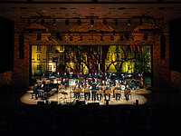 Jazzorchester spielt live auf einer beleuchteten Konzertbühne