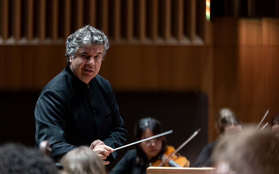 Dirigent in dunkler Kleidung